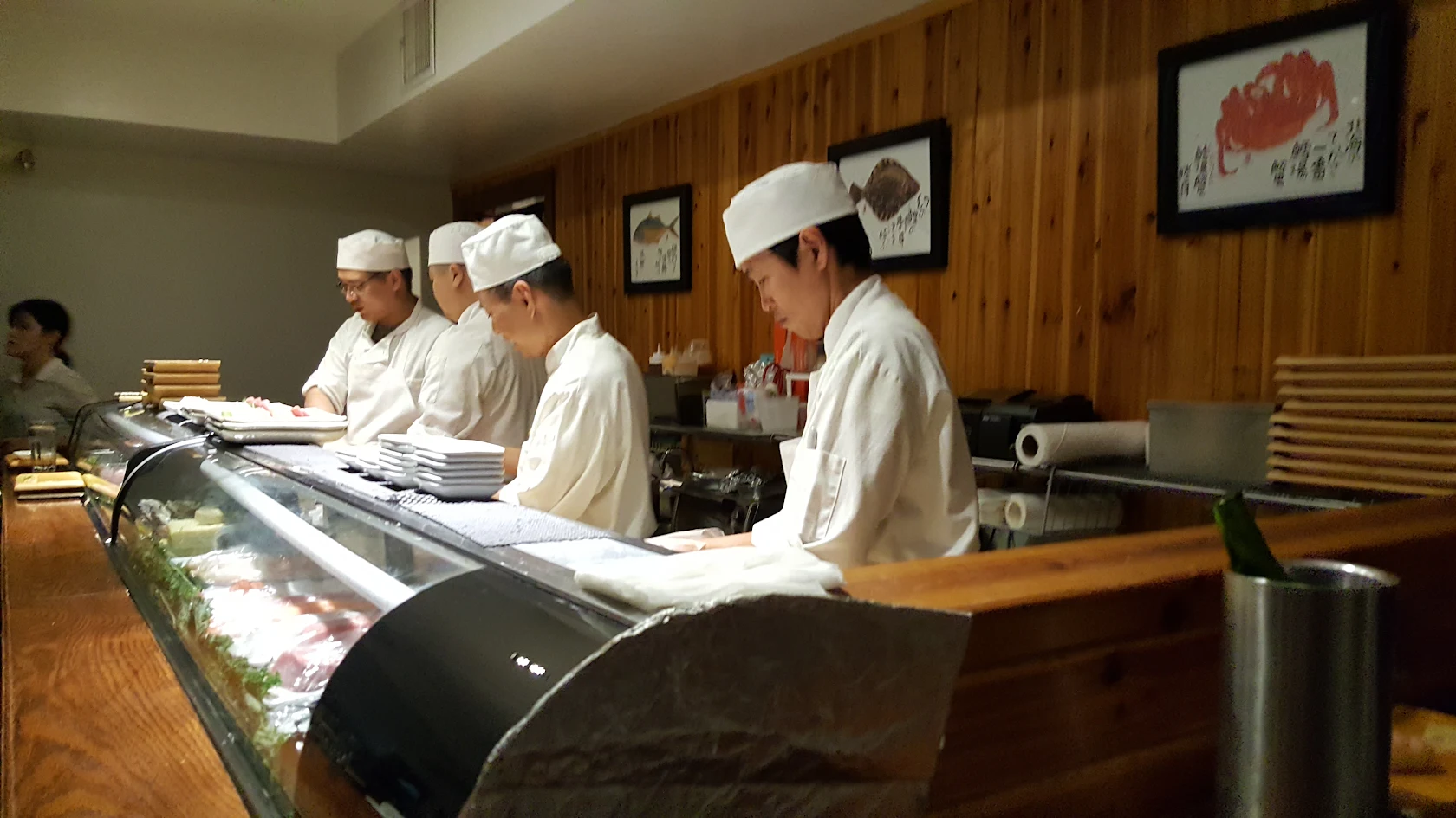 A row of chefs working the sushi counter